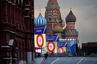 La gente hace los preparativos para un concierto en la Plaza Roja, con construcciones que leen las palabras ''Donetsk, Luhansk, Zaporiyia, Kherson, Rusia'', y la Catedral de San Basilio y el Mausoleo de Lenin en el fondo, en Moscú, Rusia, jueves, 29 de septiembre de 2022. 