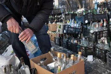 Civiles voluntarios preparan botellas vacías donadas para ser usadas como cócteles Molotov en un centro de recolección ubicado en un estacionamiento de Dnipro, Ucrania, el 27 de febrero de 2022.