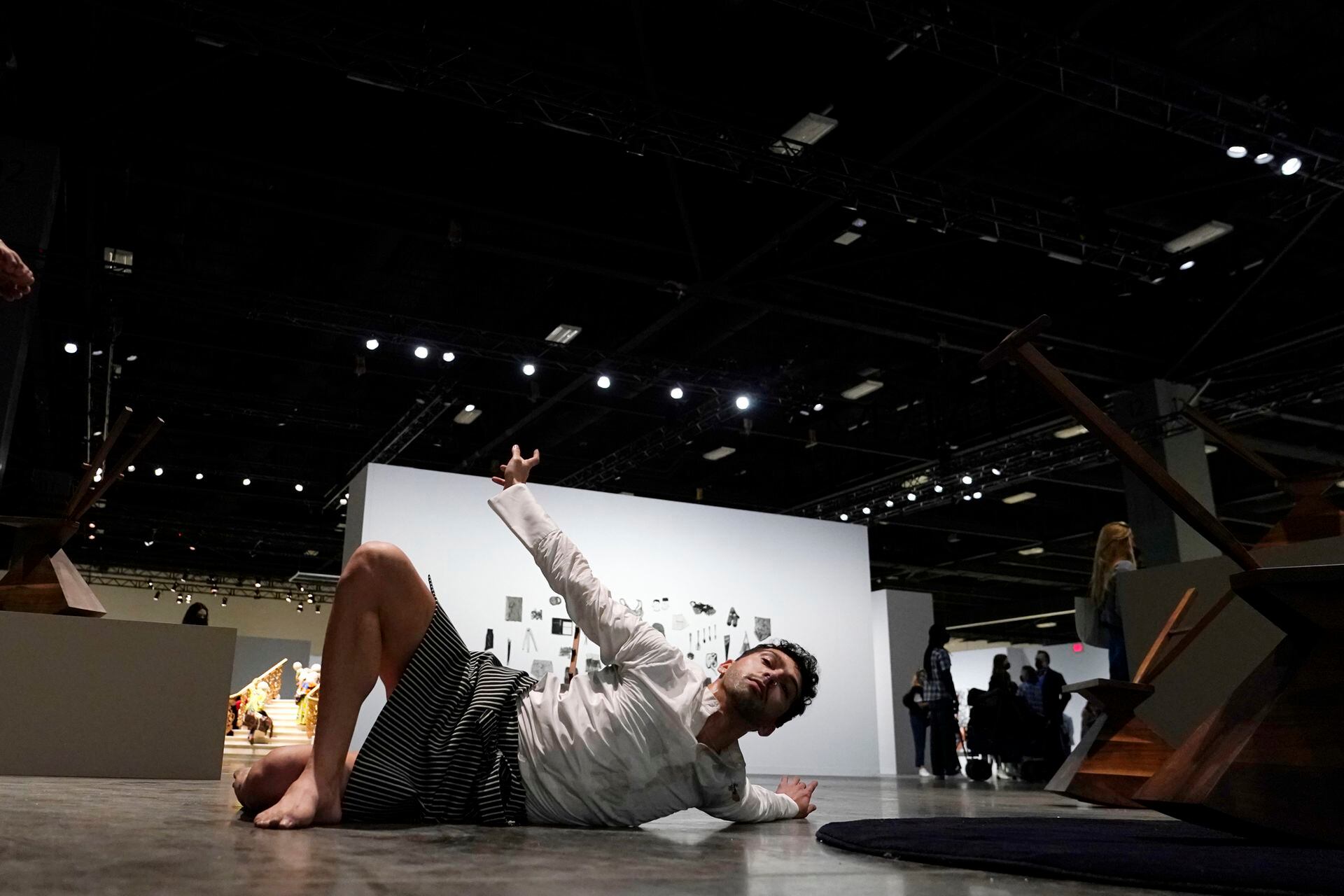 Un bailarín actúa junto a una escultura titulada "Contract and Release" del artista Brendan Fernandes durante la vista previa VIP de Art Basel Miami Beach.