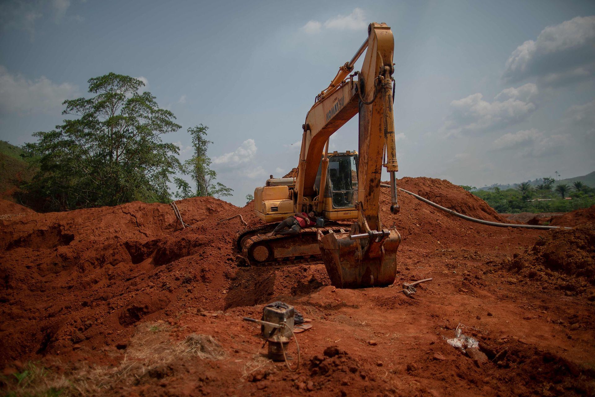 Los mineros ilegales de oro descansan sobre una maquinaria rota en una mina de oro ilegal en Sao Felix do Xingu, estado de Pará