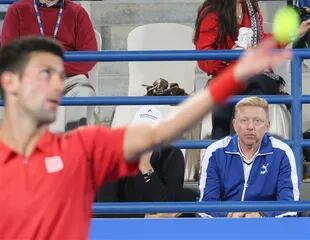 Djokovic en pleno saque, mirado de cerca por Becker