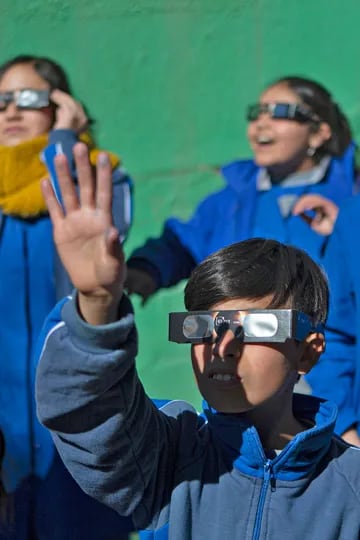 Un grupo de niños se prueba anteojos especiales para ver el eclipse