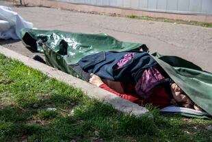El cuerpo cubierto de una mujer muerta yace en el suelo tras un bombardeo ruso en la estación de tren de Kramatorsk