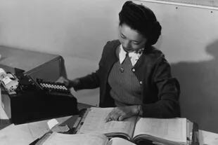 Contadora Teruko Kiyomura actualizando manualmente varios libros de contabilidad en 1943
