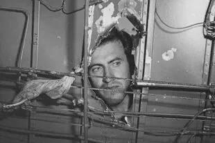 Louis Zamperini en el 'SuperMan' viendo a través de un hueco de la nave hecho por un proyectil en 1943