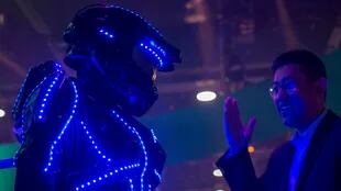 Una persona vestida de "glowbot" atrae a la gente al stand de Hisense