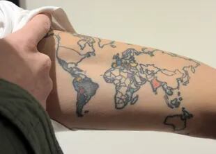 El brazo con un tatuaje de un planisferio y los países que conoce; ya estuvo en 48