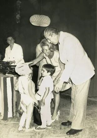 Amalita y Alfredo Fortabat en una fiesta infantil junto al pequeño Alejandro, que mira atento a un amiguito que fue disfrazado de pájaro