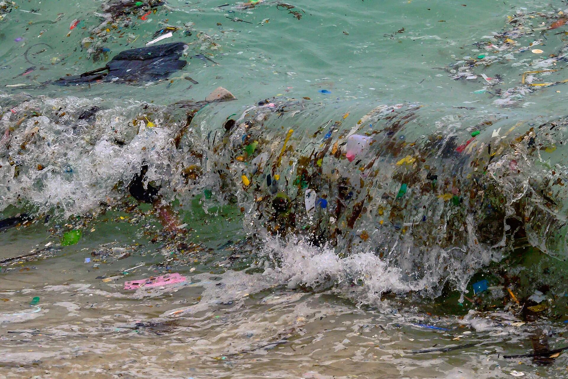 Una ola que transporta desechos plásticos y todo tipo de basura llega a una playa en Koh Samui, en el Golfo de Tailandia.