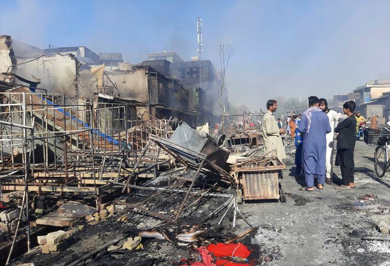 Afganos inspeccionan tiendas dañadas después de los enfrentamientos entre los talibanes y las fuerzas de seguridad afganas en la ciudad de Kunduz, en el norte de Afganistán