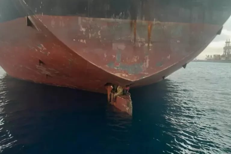 Shocking footage shows three migrants on board the ship’s rudder blade