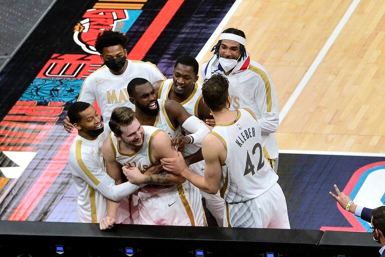 Luka Doncic (centro, abajo), de Dallas Mavericks, es felicitado por sus compañeros tras lograr triple del triunfo sobre los Grizzlies