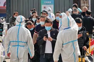 Los trabajadores de la salud guían a los viajeros a una estación de inspección del coronavirus Covid-19 en la estación de tren de Yantai en la provincia de Shandong, en el este de China