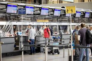 Los pasajeros hacen cola en el mostrador de facturación del aeropuerto de Schiphol en Ámsterdam, el 15 de junio de 2020