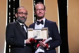 El realizador iraní Asghar Farhadi y su par filandés Juho Kuosmanen posan junto a sus premios compartidos por sus films Ghahreman (A Hero) y Compartment No. 6
