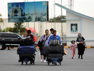 Pasajeros se dirigen a la terminal de salidas del aeropuerto internacional Hamid Karzai en Kabul, Afganistán, para abandonar el país