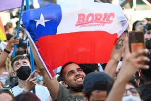 Simpatizantes del candidato presidencial chileno Gabriel Boric, del partido Apruebo Dignidad, celebran tras los primeros resultados oficiales de la segunda vuelta de las elecciones presidenciales, en Santiago, el 19 de diciembre de 2021.