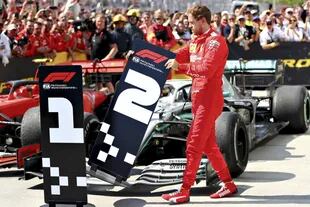 Después de la penalización, Sebastian Vettel modifica la posición de los carteles de primero y segundo, con Lewis Hamilton; el alemán y el británico mantienen una respetuosa rivalidad
