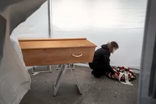 Un empleado de "Pompes Funebres Generales Geneve" muestra una habitación con un ataúd en una funeraria temporal hecha con carpas, en Carouge, cerca de Ginebra, el 30 de noviembre de 2020