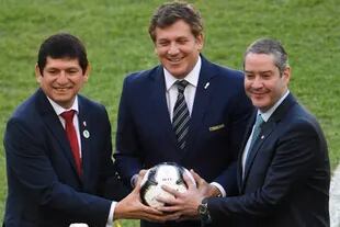 El presidente de la Confederación Brasileña de Fútbol, Rogério Caboclo, a la derecha, sostiene un balón junto a sus pares de la federación peruana, Agustin Lozano, y Conmebol, Alejandro Domínguez.