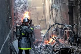 Un bombero palestino apaga las llamas tras el ataque israelí en la Franja de Gaza. (Mohammed ABED / AFP)