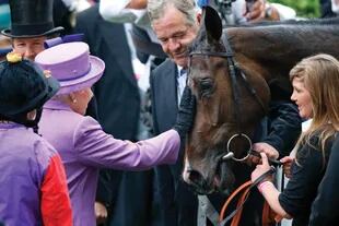 La Reina Isabel II acaricia a Estimate, después de que su yegua ganó la Gold Cup de 2013 en Royal Ascot, un festival al que solamente faltó este año