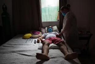 La enfermera Marcicleia Gomes cuida a su hermano, el técnico de enfermería Marcio Moraes, de 43 años, quien está infectado con Covid-19, en su casa de Manaus, Brasil, el 28 de enero de 2021