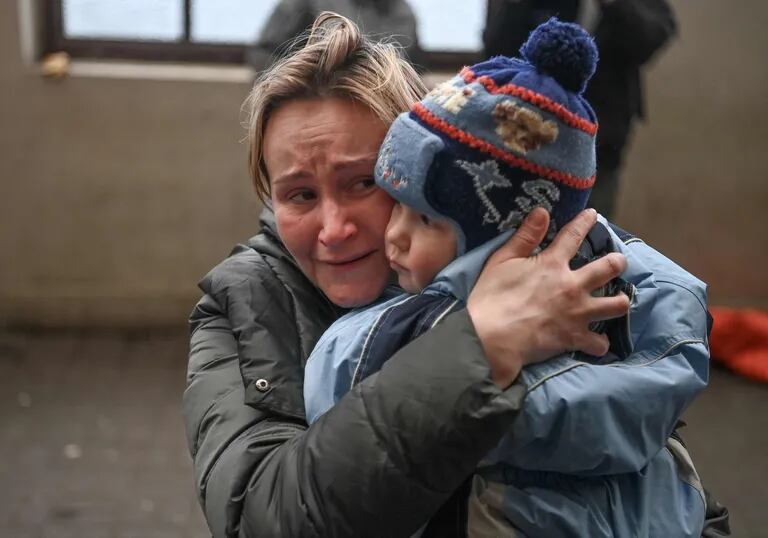 Una mujer sostiene a su hijo mientras intenta abordar un tren gratuito a Polonia en una estación de tren en Lviv, Ucrania occidental, el 3 de marzo de 2022