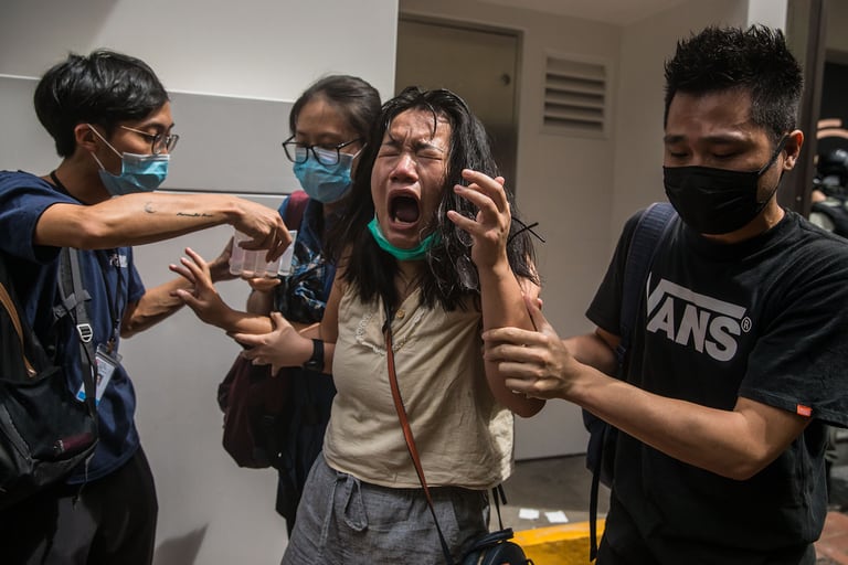 Una mujer reacciona al gas pimienta durante una protesta contra una nueva ley de seguridad nacional en Hong Kong el 1 de julio de 2020