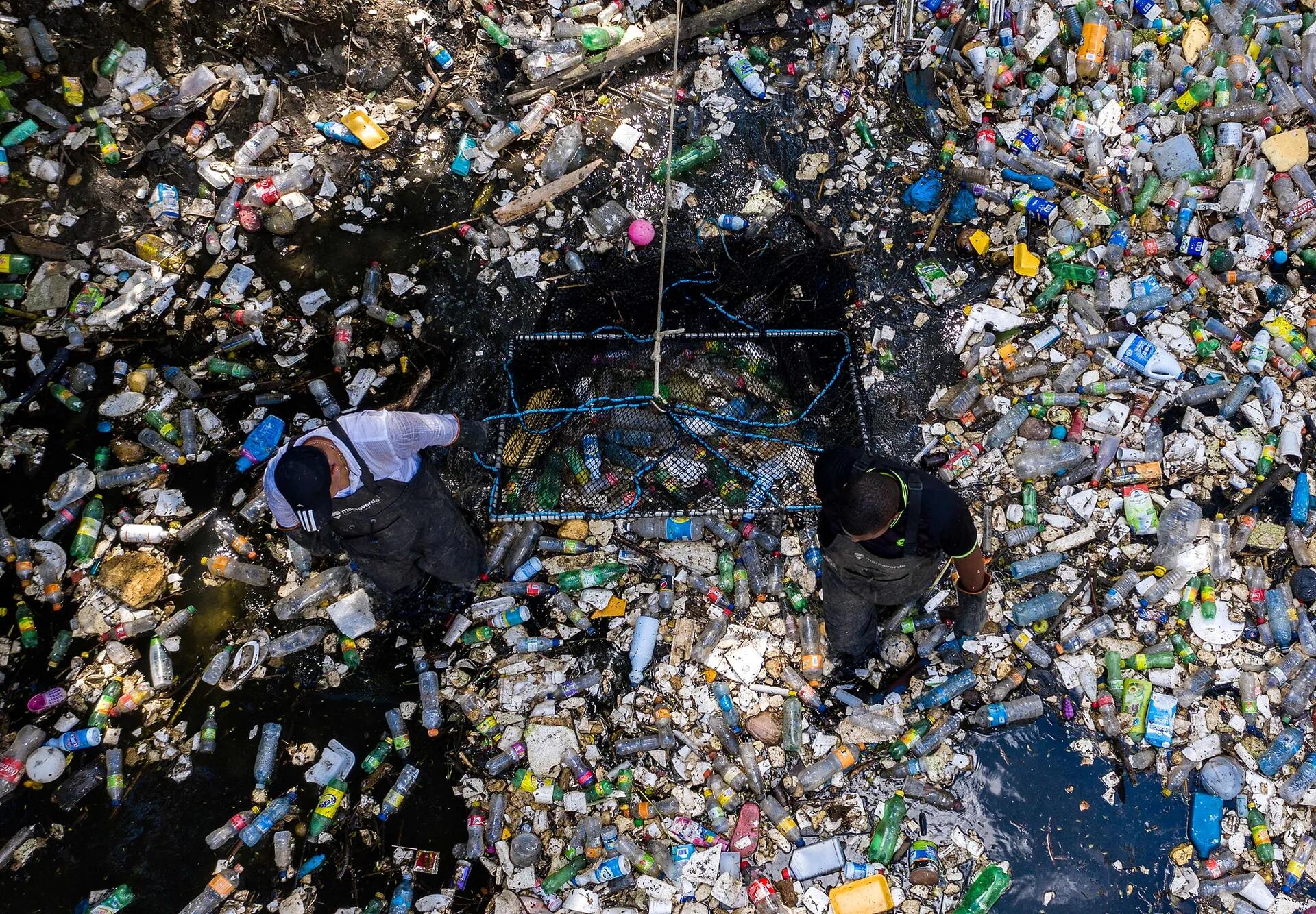 Trabajadores recolectan basura, incluidos desechos plásticos, en el río Matías Hernández en Costa del Este, Ciudad de Panamá.