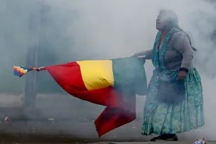 Una seguidora de Evo Morales camina por la calle mientras agita una bandera bolivana