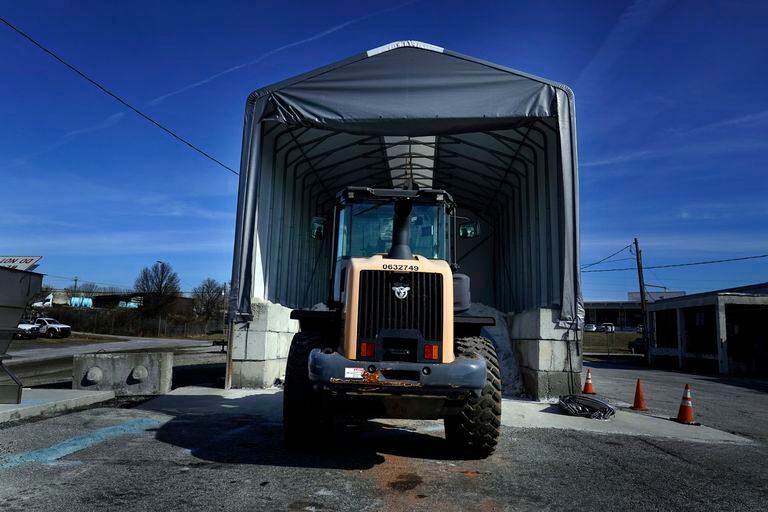 Un tractor, ante una pila de sal empleada para evitar la formación de hielo en la carretera durante una nevada, en la sede de la unidad de actividades de mantenimiento de GDOT, el 14 de enero de 2022, en Forest Park, Georgia. (AP Foto/Brynn Anderson)