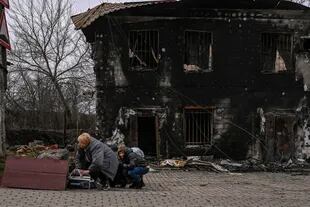 Un grupo de personas se cubre durante un bombardeo en Bucha, al oeste de Kiev, el 4 de marzo de 2022