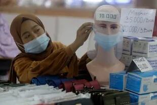 Los trabajadores más jóvenes, como esta vendedora de Yakarta, son vistos como la población clave para combatir el virus
