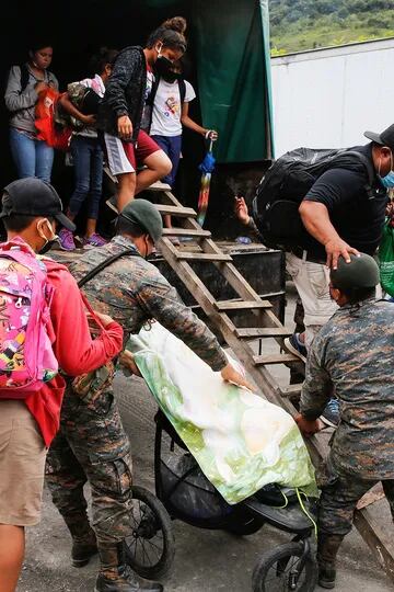 Los migrantes hondureños que intentaban llegar a los Estados Unidos se bajan de un vehículo militar cuando son enviados de regreso por las autoridades guatemaltecas en la frontera de El Florido entre Guatemala y Honduras
