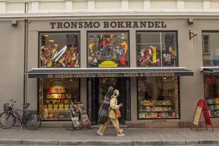 Una violonchelista pasa junto a Tronsmo, la librería independiente más antigua de la ciudad con una gran selección de cómics y libros en otros idiomas.