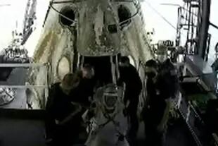 Esta captura de la NASA muestra al personal de recuperación ofreciendo asistencia mientras el astronauta de la NASA Bob Behnken sale de la nave espacial SpaceX Crew Dragon, frente a la costa de Pensacola, en Florida, el 2 de agosto de 2020