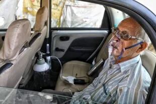 Sushil Kumar Srivastava fue fotografiado en su auto, conectado a una botella de oxígeno en la ciudad de Lucknow