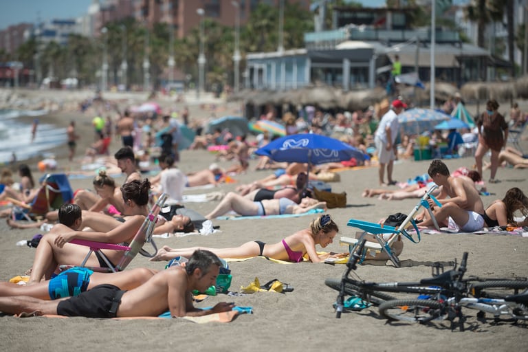 Las personas toman el sol en la playa de La Misericordia en Málaga el 7 de junio de 2020, mientras se alivian las medidas de bloqueo durante la pandemia de coronavirus