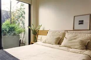 El dormitorio se ilumina por un segundo patio decorado con macetones de jazmín y romerino. Edredón y almohadones en lino crudo (Arredo).