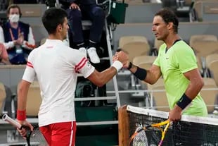 El serbio Novak Djokovic y el español Rafael Nadal se despiden al término de su partido de semifinales del Abierto de Francia que el primero ganó por 3-6, 6-3, 7-6 (4), 6-2 en el estadio Roland Garros en París, el viernes 11 de junio de 2021