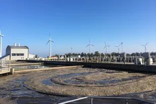La mayor planta de tratamiento del agua en Copenhague y, detrás, molinos eólicos