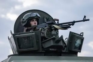 Un soldado de la Guardia Nacional ucraniana custodia un puesto de control móvil junto a agentes de los servicios de seguridad y policías durante una operación conjunta, en Kharkiv, Ucrania, el 17 de febrero de 2022. (AP Foto/Evgeniy Maloletka)