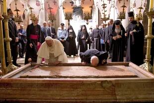El Papa Francisco y el Patriarca de Constantinopla Bartolomé se arrodillan para besar la Piedra de la Unción, tradicionalmente reivindicada como la piedra donde el cuerpo de Jesús fue preparado para el entierro, en la Iglesia del Santo Sepulcro, en Jerusalén el 25 de mayo de 2014