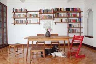 Mesa y sillas (Sticotti). La obra de arte es de Mariana Sissia. La biblioteca (Sticotti) es la protagonista del comedor. Encastrable y colgante, se adaptó a cada casa en la que vivieron.