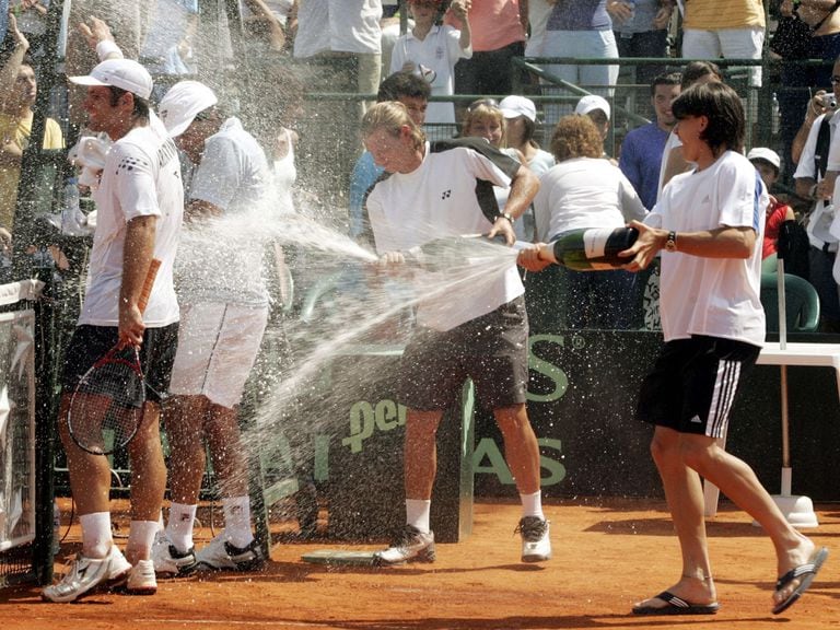 Un joven Guillermo Coria le lanza champagne a David Nalbandian en el único triunfo argentino sobre República Checa, en 2005