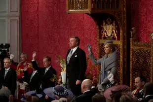 Como es tradición, al final del discurso, la reina y los invitados levantan su mano derecha para saludar a su rey. (AP Photo/Peter Dejong)