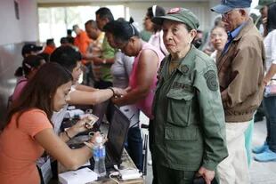 Una mujer vestida se dispone a votar en un centro electoral de Caracas