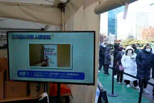 Un grupo de personas espera para someterse a las pruebas del coronavirus frente a un centro de salud pública en Seúl, Corea del Sur, el jueves 17 de febrero de 2022.