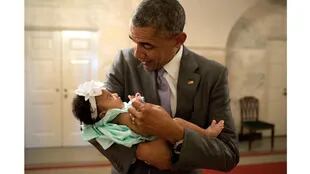 El presidente Barack Obama tiene a la hija de Darienne Page Rakestraw y de London Rakestraw en el corredor de la planta baja de la Casa Blanca, el 1 de julio de 2014.